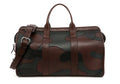 Camouflage patchwork duffel bag in brown and black leather with silver buckle and shoulder strap, front view