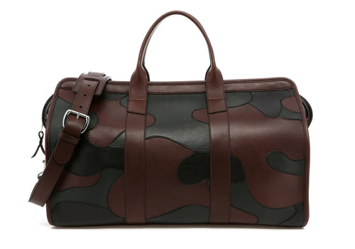 Camouflage patchwork duffel bag in brown and black leather with silver buckle and shoulder strap, front view