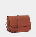 Rust-brown leather crossbody bag with a fold-over flap, gold clasps and an adjustable shoulder strap